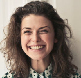 dentysta Katowice uśmiechnięta kobieta w kręconych włosach