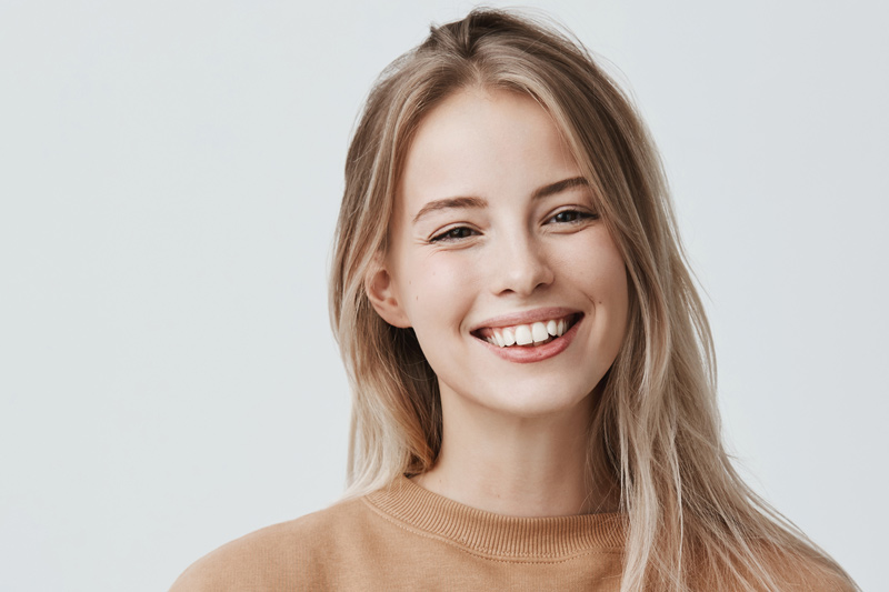 stomatologia zachowawcza wizyta kontrolna uśmiechnięta blondynka