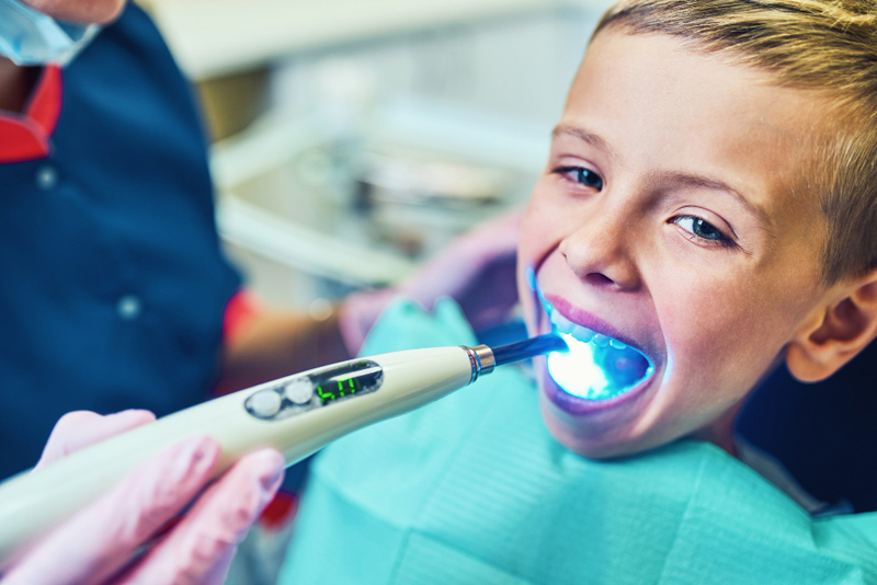 Lakierowanie – fluoryzacja zębów chłopiec w gabinecie stoamtologicznym